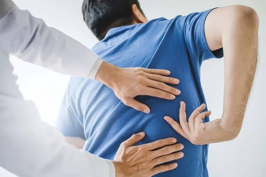 Therapist helping patient with back pain