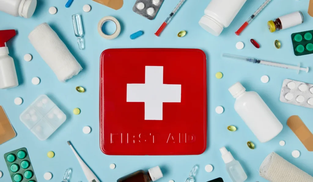 A wide variety of medical equipment surrounding a first aid kit on a blue background.